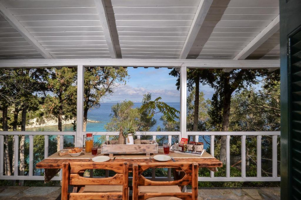 a table on a porch with a view of the ocean at KATINA COTTAGE in Kontogiannátika