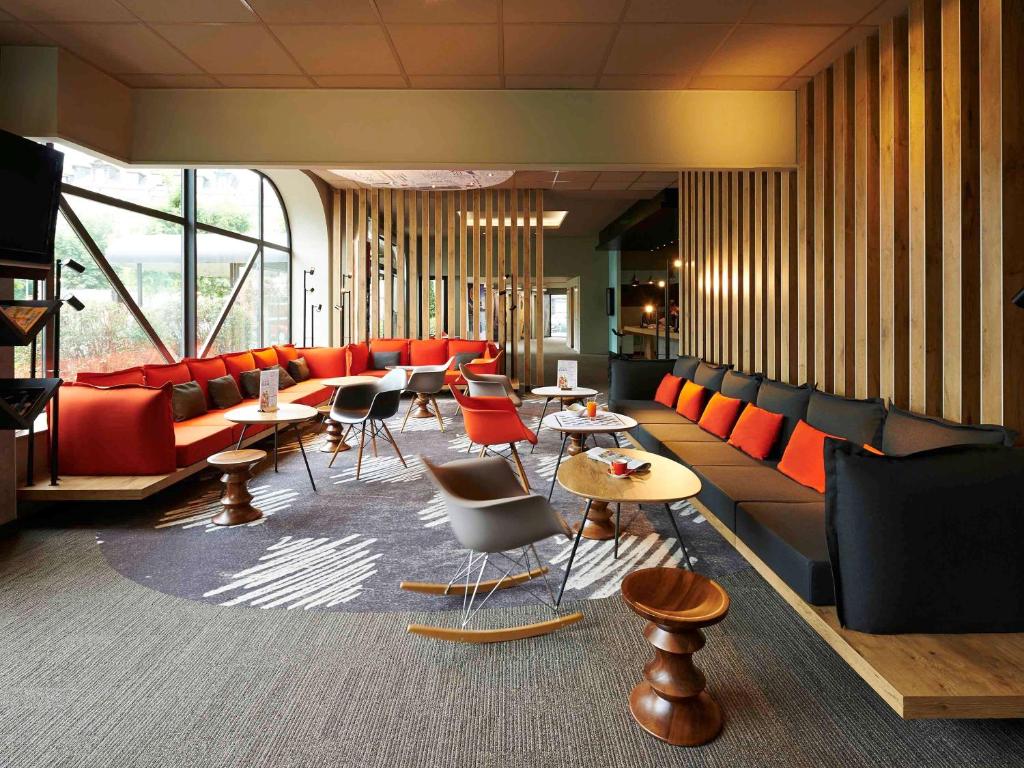 a lobby with a couch and tables and chairs at ibis Strasbourg Centre Historique in Strasbourg