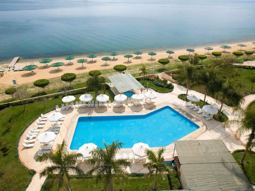 an aerial view of a swimming pool and the beach at Mercure Ismailia Forsan Island in Ismailia