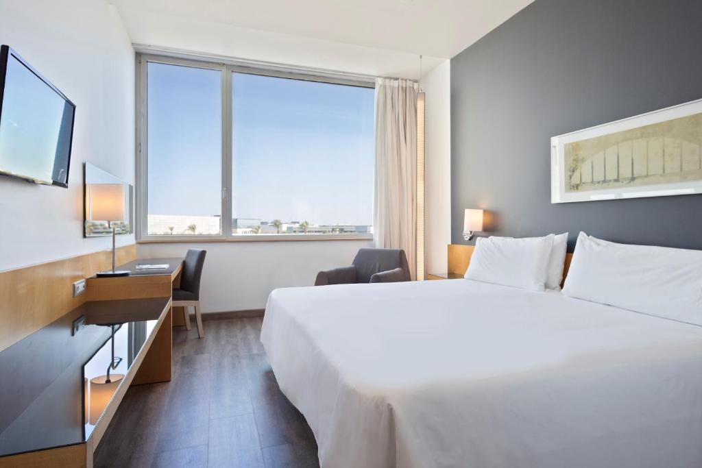 una camera d'albergo con un grande letto e una grande finestra di Hotel Barcelona Aeropuerto, affiliated by Meliá a El Prat de Llobregat