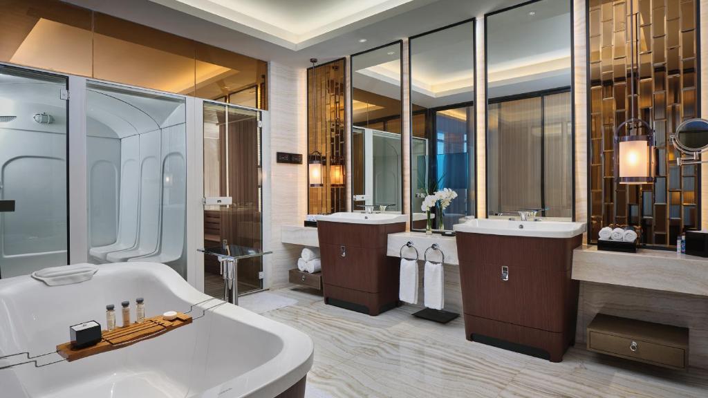 ein großes Badezimmer mit zwei Waschbecken, einer Badewanne und einer Badewanne in der Unterkunft InterContinental Xiamen, an IHG Hotel in Xiamen