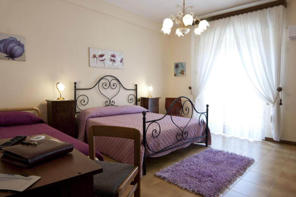 1 dormitorio con 2 camas y mesa en Armonia B&B, en Trapani