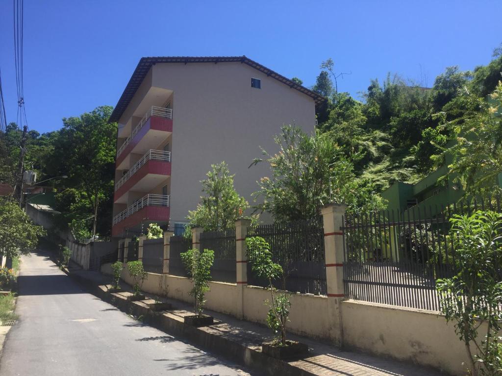 a fence in front of a building next to a street at Apart Hotel Angra dos Reis II in Angra dos Reis