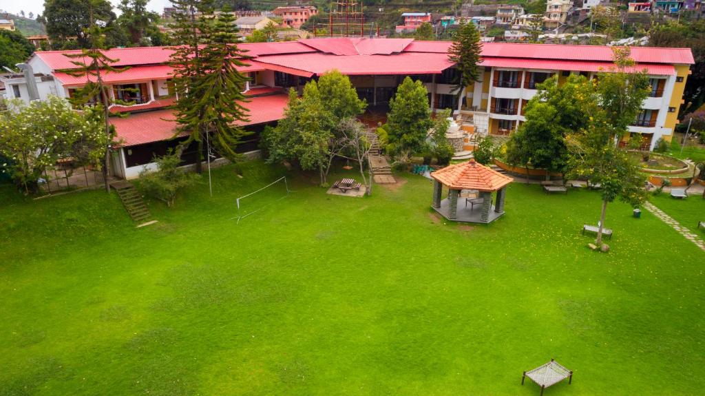 una vista aérea de un gran patio verde con un edificio en Hotel Kodai International, en Kodaikanal