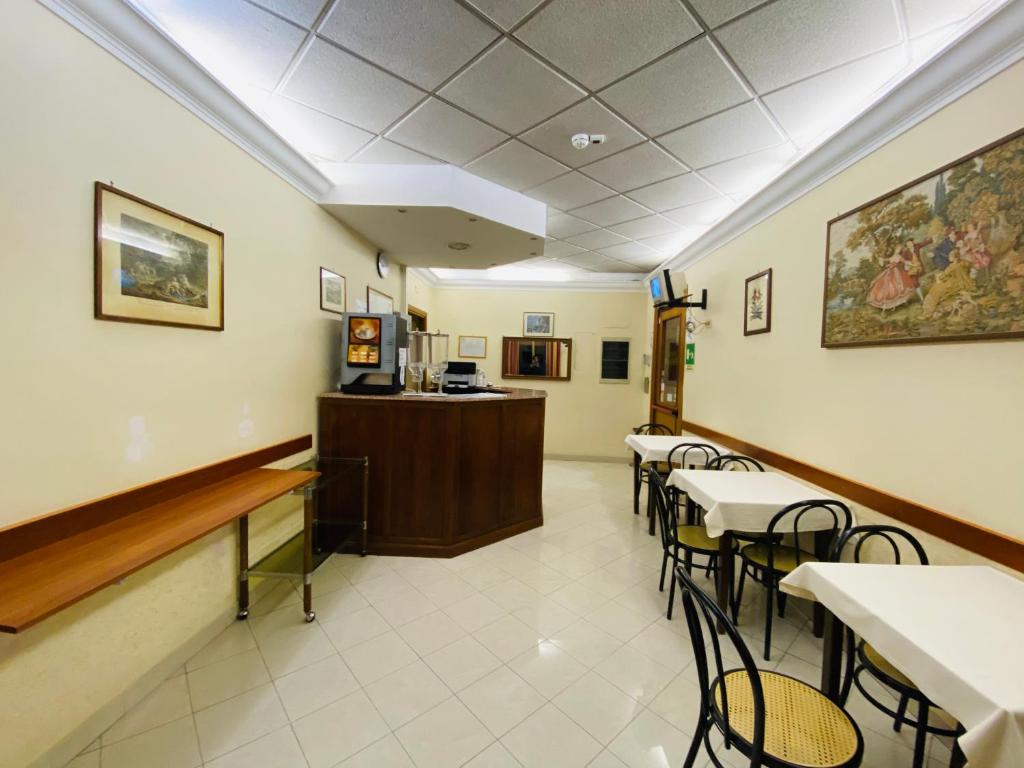 ein Wartezimmer mit Tischen, Stühlen und einer Theke in der Unterkunft Hotel Ferrari in Rom