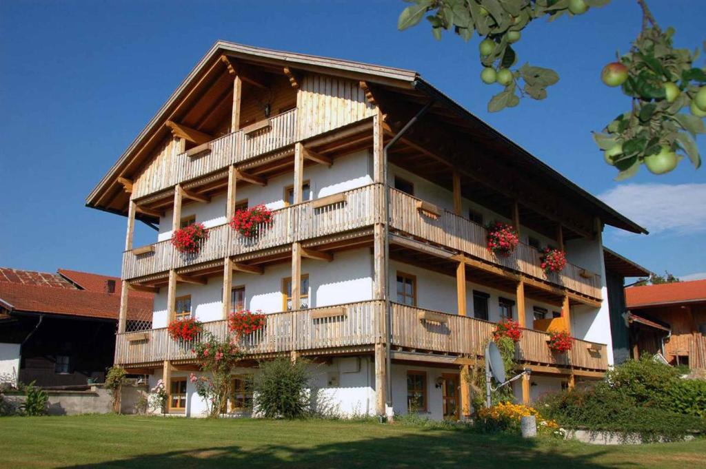 un gran edificio con macetas en los balcones en Erlebnisbauernhof Sternhof en Bodenmais