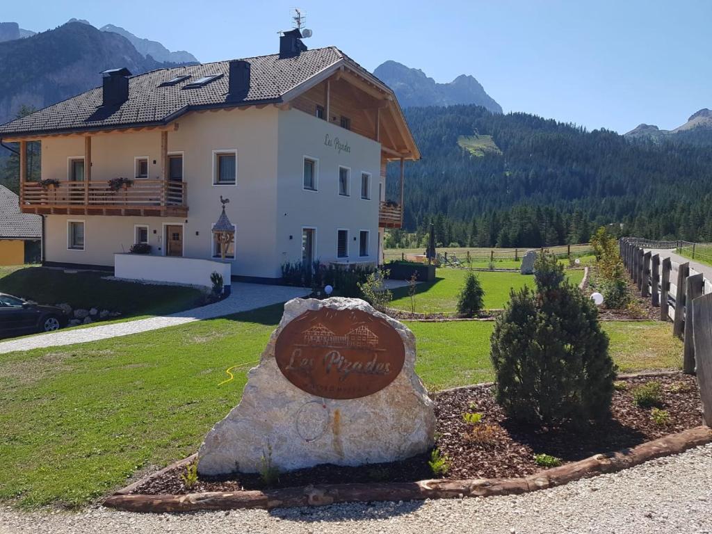 a house with a large rock in front of it at Les Pizades in San Cassiano