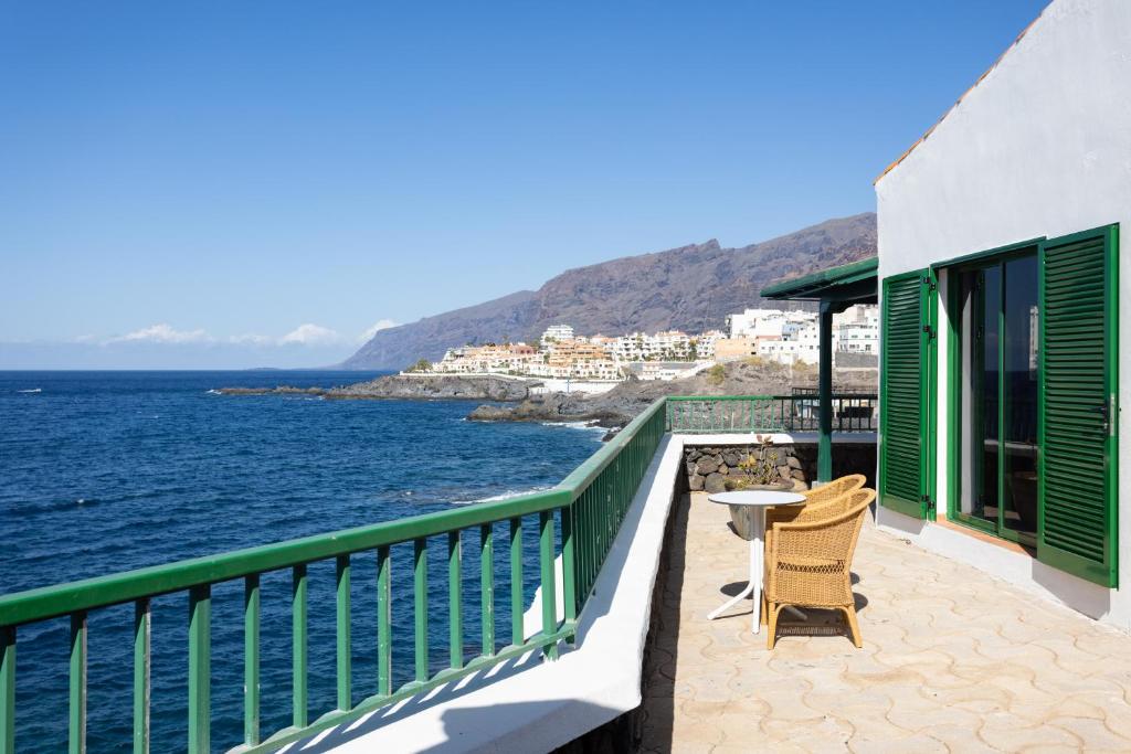 balcón con mesa, sillas y vistas al océano en Villa Privada Mirador de La Gomera con jacuzzi, en Puerto de Santiago