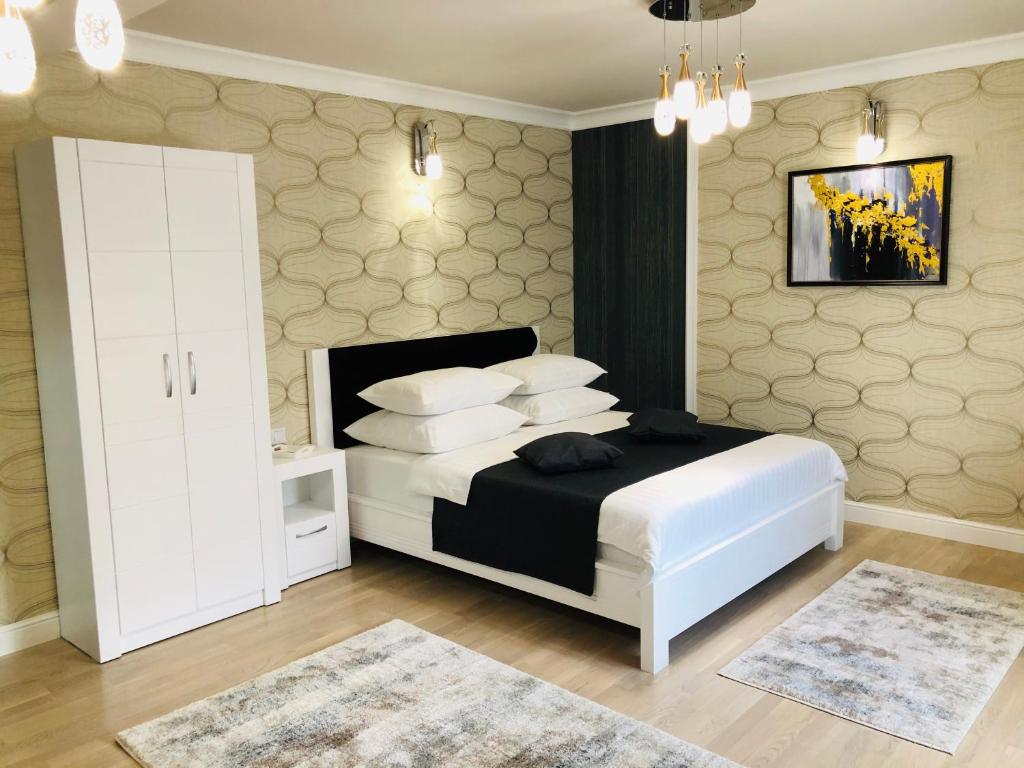 a bedroom with a white bed and a white cabinet at The Classic Studio in Buzău