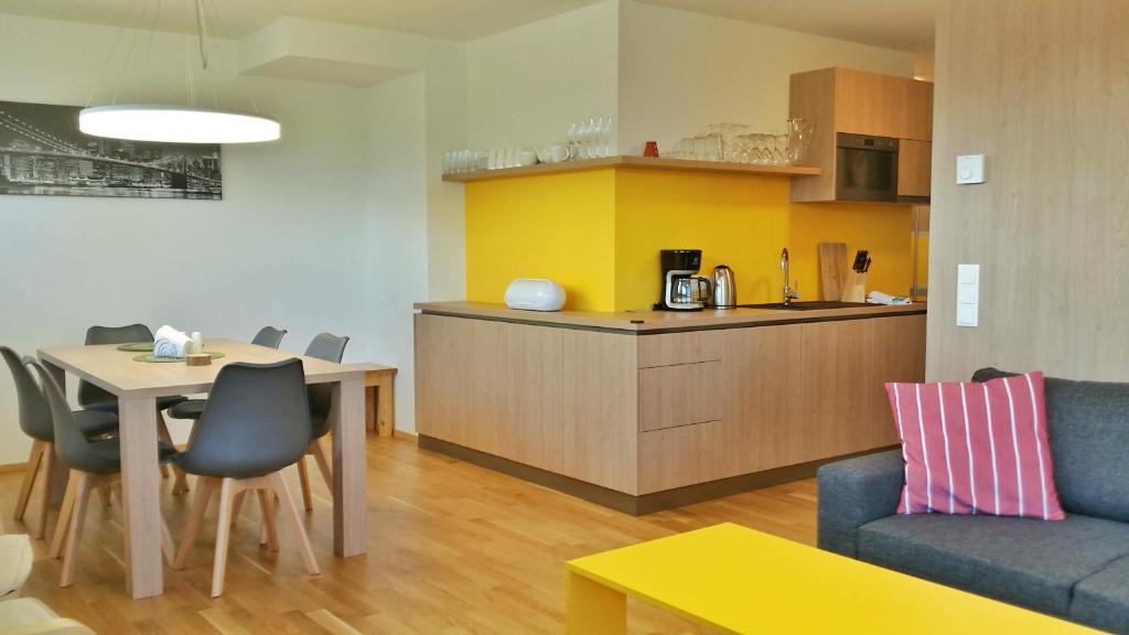 een woonkamer met een tafel en een keuken bij Apartment Fastenberg Schladming - Top11 by AA Holiday Homes in Schladming