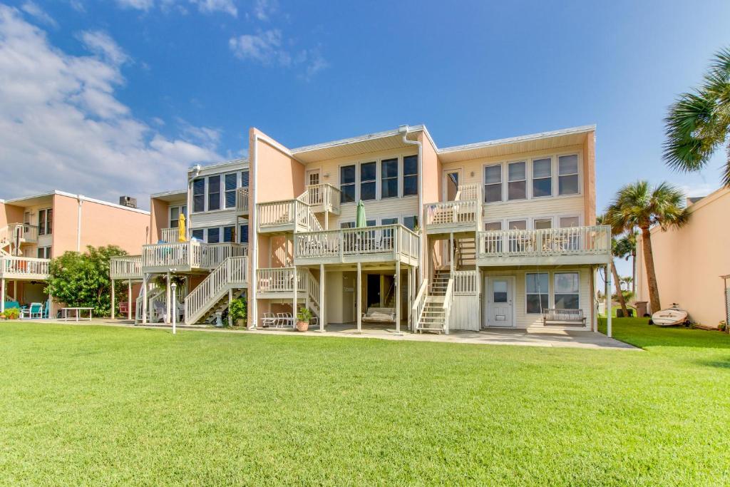 een groot appartementencomplex met balkons en een tuin bij The Treehouse On the Bay in Pensacola Beach