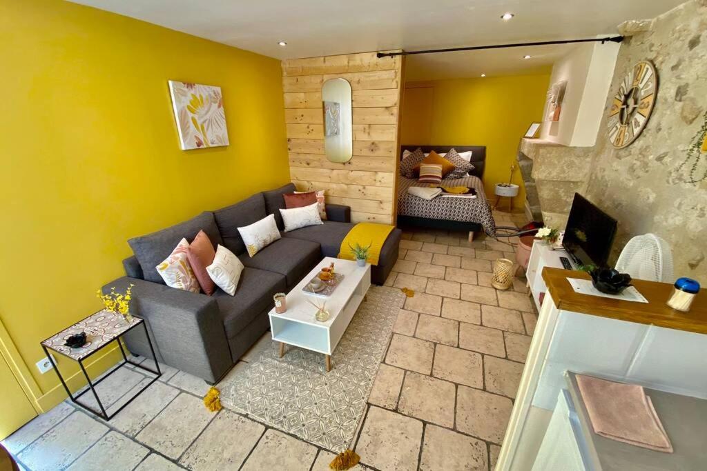 a living room with a gray couch and a yellow wall at Cocon de Douceur : Apaisement et Harmonie intérieure in Blois