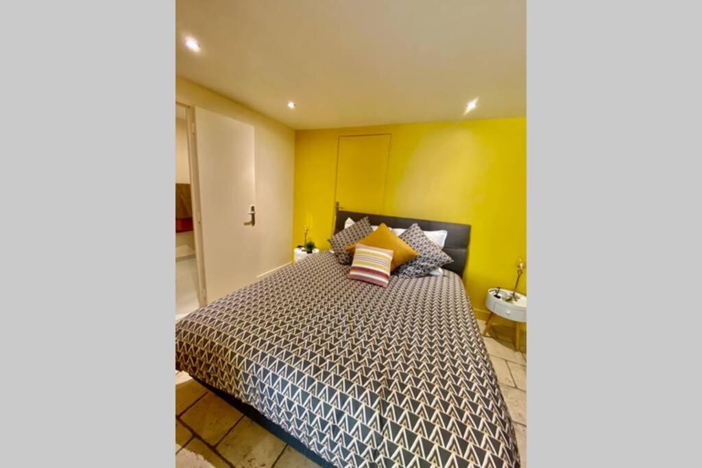 a bedroom with a large bed with yellow walls at Cocon de Douceur : Apaisement et Harmonie intérieure in Blois