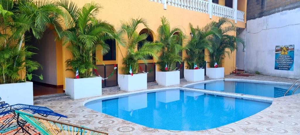 een zwembad met palmbomen voor een gebouw bij Hotel Campo Real Plus Tamasopo in Tamasopo