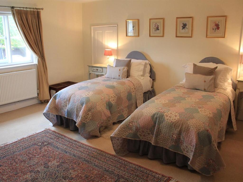 sypialnia z 2 łóżkami i dywanem w obiekcie Church Farmhouse B & B w mieście Kennett