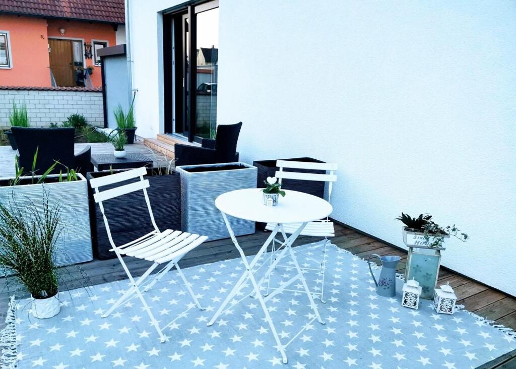 einen weißen Tisch und zwei Stühle auf einer Terrasse in der Unterkunft Marie Antoinette in Schwandorf in Bayern