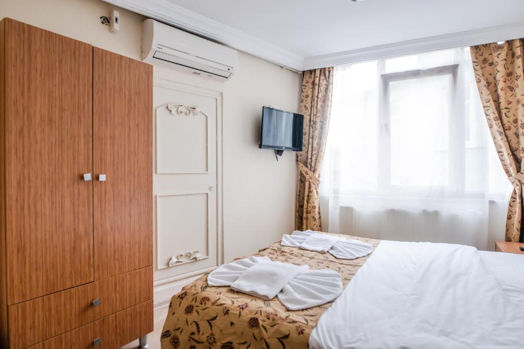 A bed or beds in a room at Camelot Apartment
