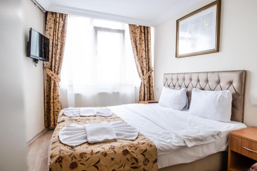 A bed or beds in a room at Camelot Apartment