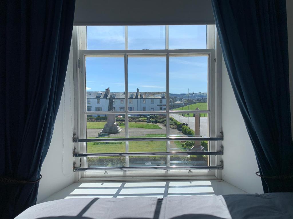 een slaapkamerraam met uitzicht op een gebouw bij Ayr Apartment with Sea and Countryside views in Ayr