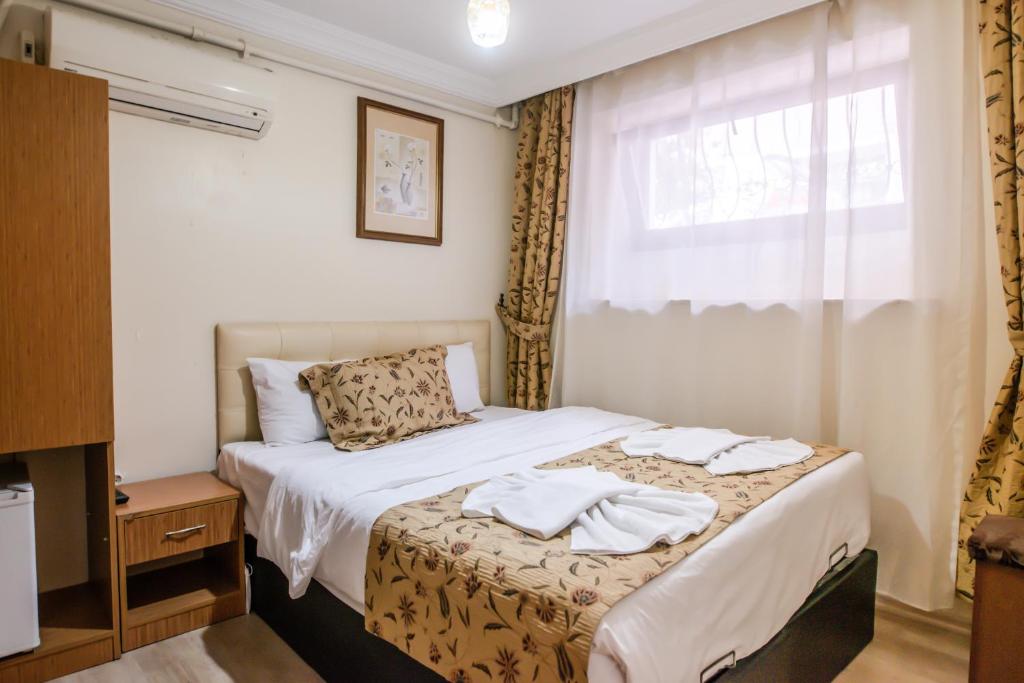 A bed or beds in a room at Camelot Apartment