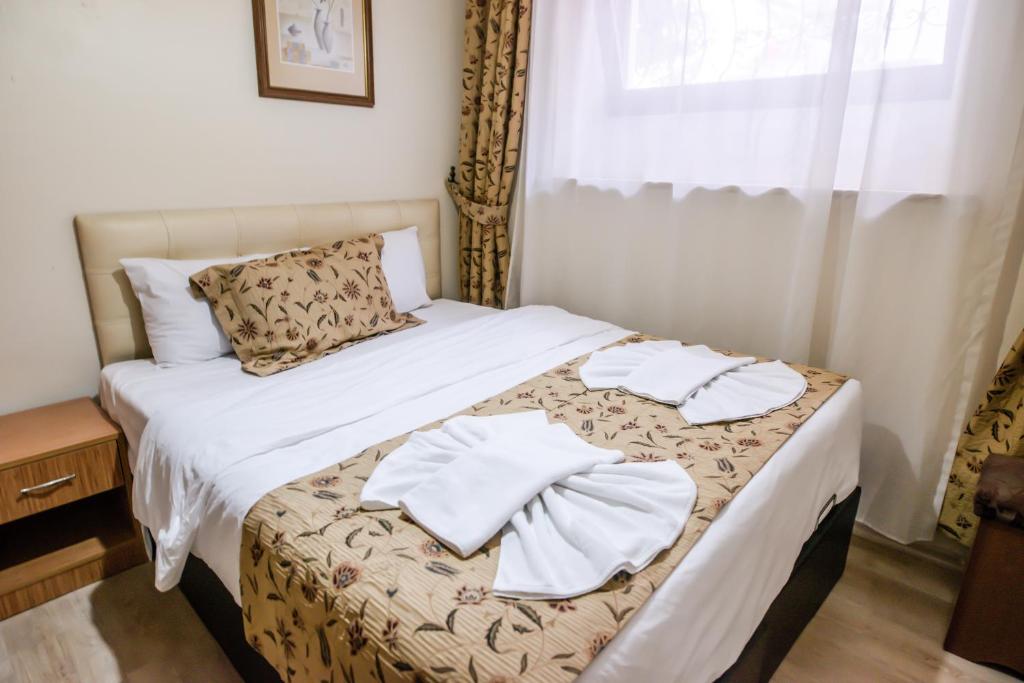 A bed or beds in a room at Camelot Apartment