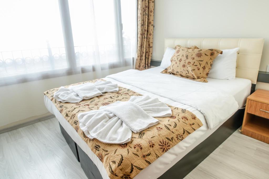 A bed or beds in a room at Camelot Apartment