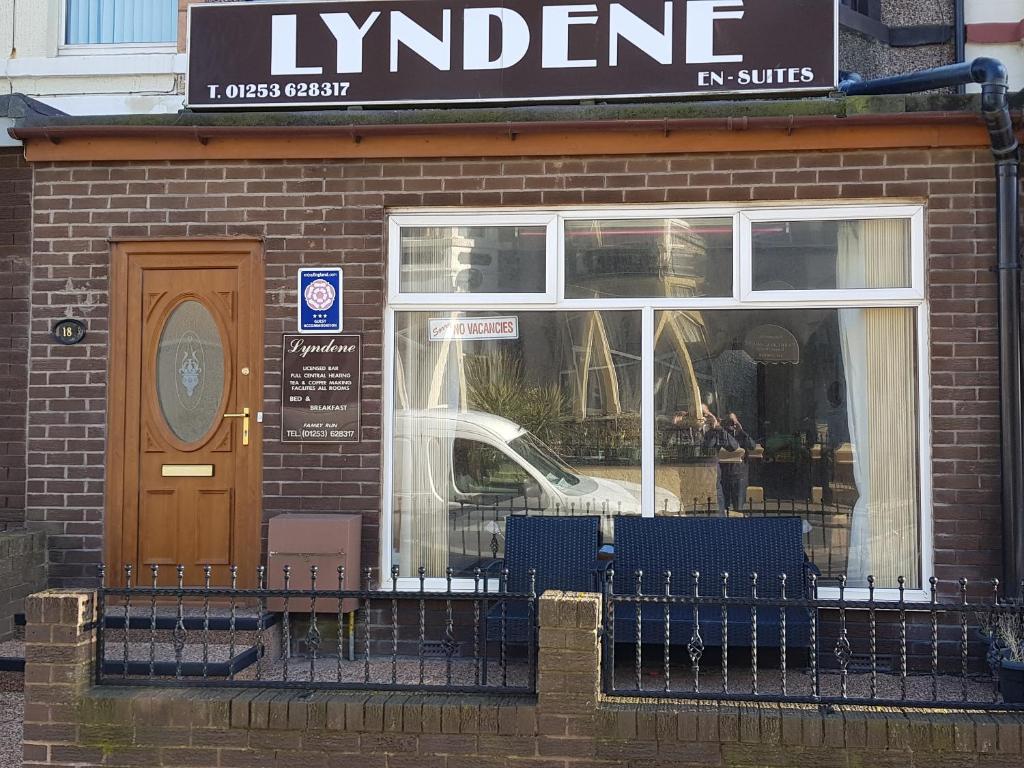 ブラックプールにあるLyndene Guest Houseの建物前の青いベンチ2つ付きの店