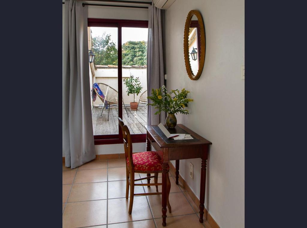a desk with a chair and a mirror in a room at Le Clos des Chênes in Lagarde-Paréol