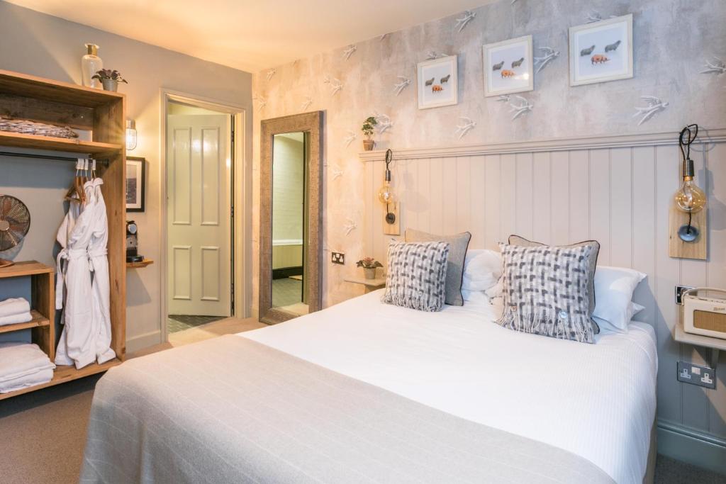 a bedroom with a large white bed with two pillows at The Angel & Blue Pig in Lymington