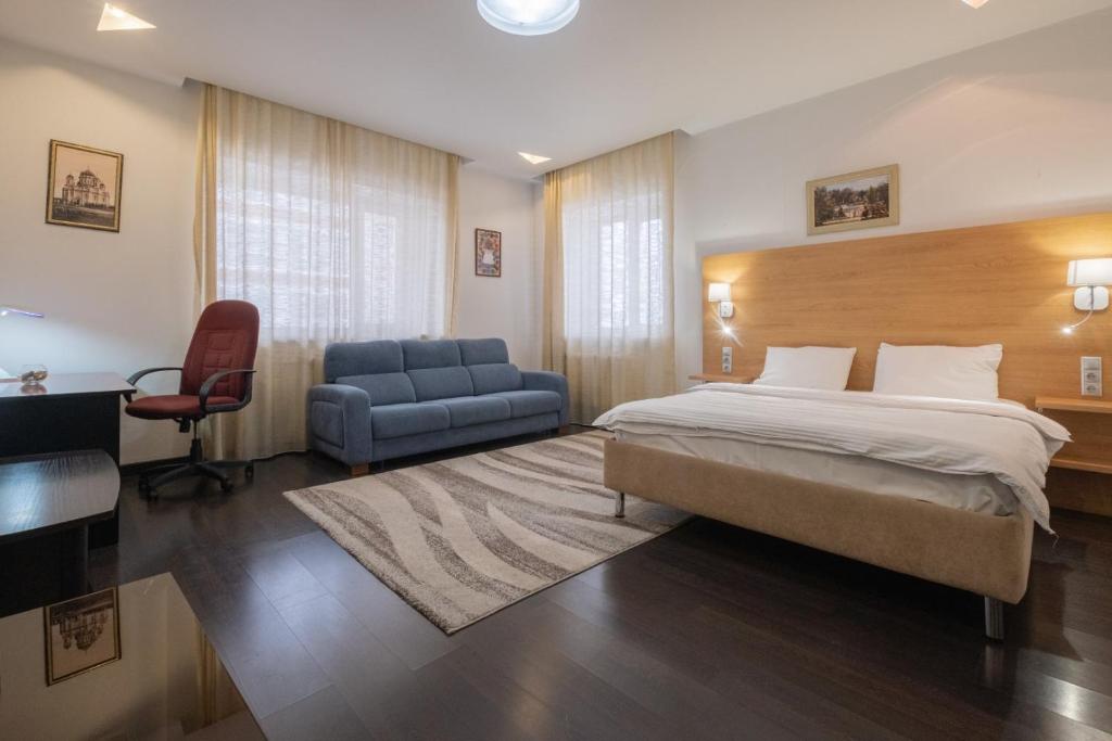 a hotel room with a bed and a chair at Апартаменты Петровские 90 кв в центре с хорошим видом in Tomsk
