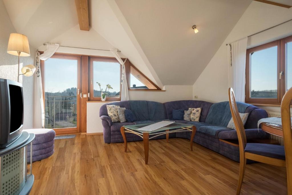 a living room with a blue couch and a table at Ferienhof Sauter Friedrichshafen in Neukirch