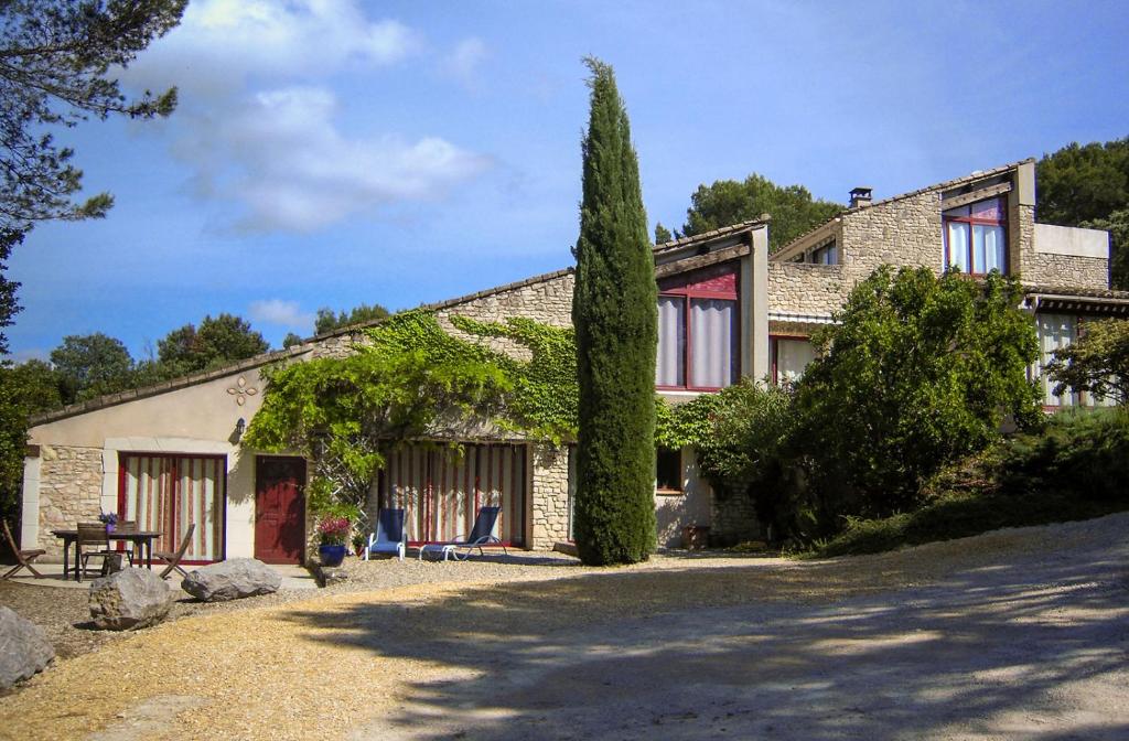 ein Haus mit zwei Stühlen und einem Baum in der Unterkunft Le Clos des Chênes in Lagarde-Paréol