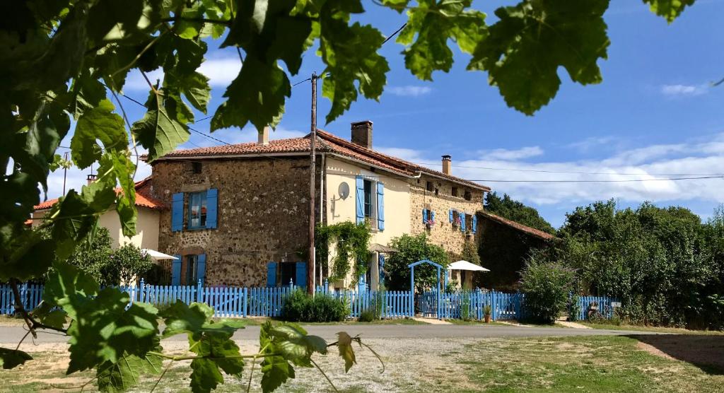 une vieille maison avec une clôture bleue devant elle dans l'établissement Gites Limousin - La Vienne, à Videix