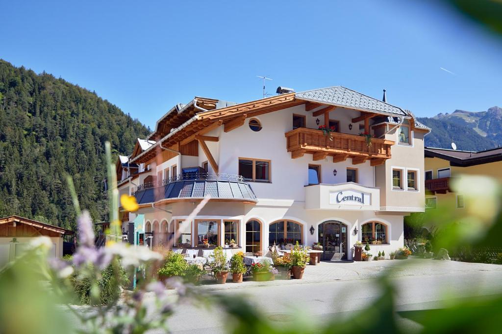 a large white building with a balcony at Hotel Central - das kleine Boutique Hotel am Achensee in Pertisau