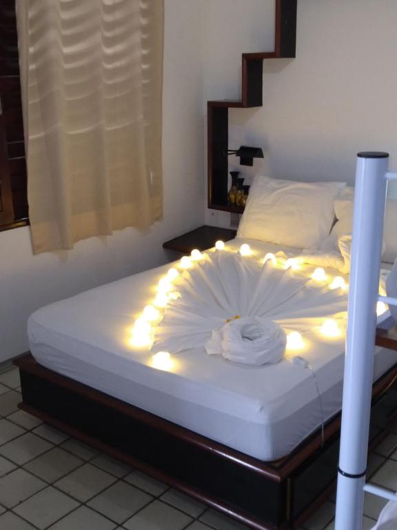 Una cama con luces encendidas en una habitación en O Portuga Pousada en João Pessoa