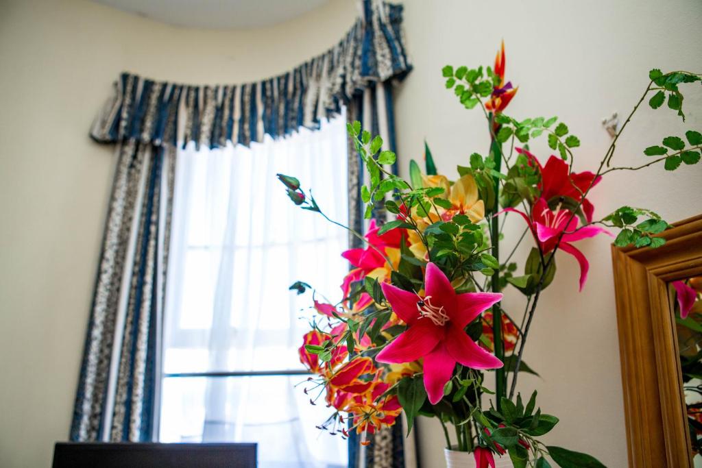 un vase avec des fleurs devant une fenêtre dans l'établissement Yelf's Hotel, à Ryde