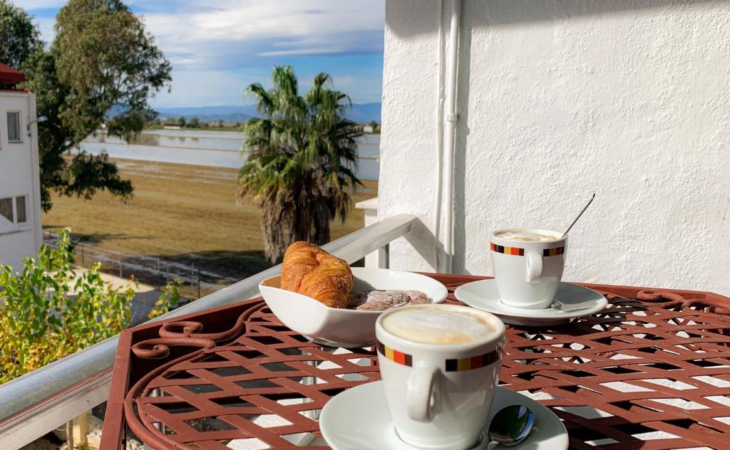 einen Tisch mit zwei Tassen Kaffee und einem Teller Essen in der Unterkunft Apartamento Delta Escapada in L'Eucaliptus