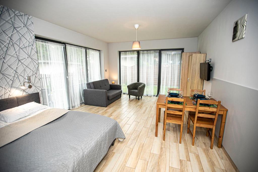 a bedroom with a bed and a table with a chair at Apartamenty PIER in Stegna
