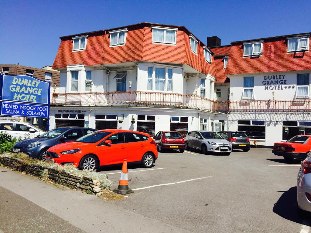 a parking lot with cars parked in front of a building at Durley Grange Hotel in Bournemouth