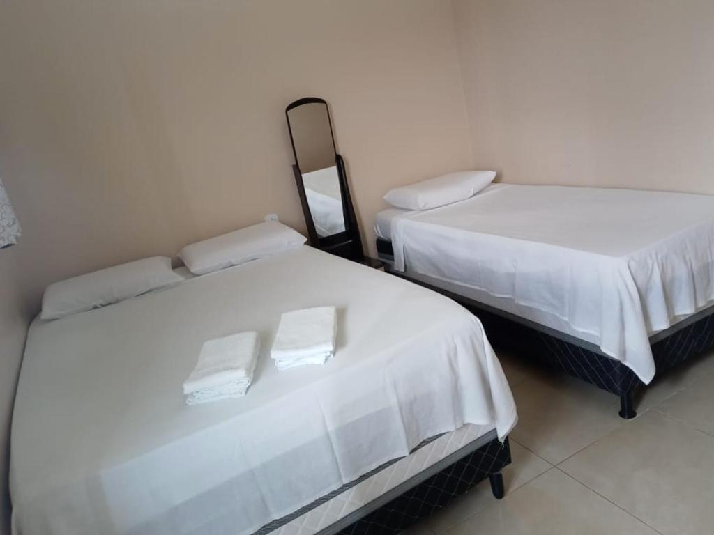 two beds sitting next to each other in a room at Pousada Nathymar in Piranhas