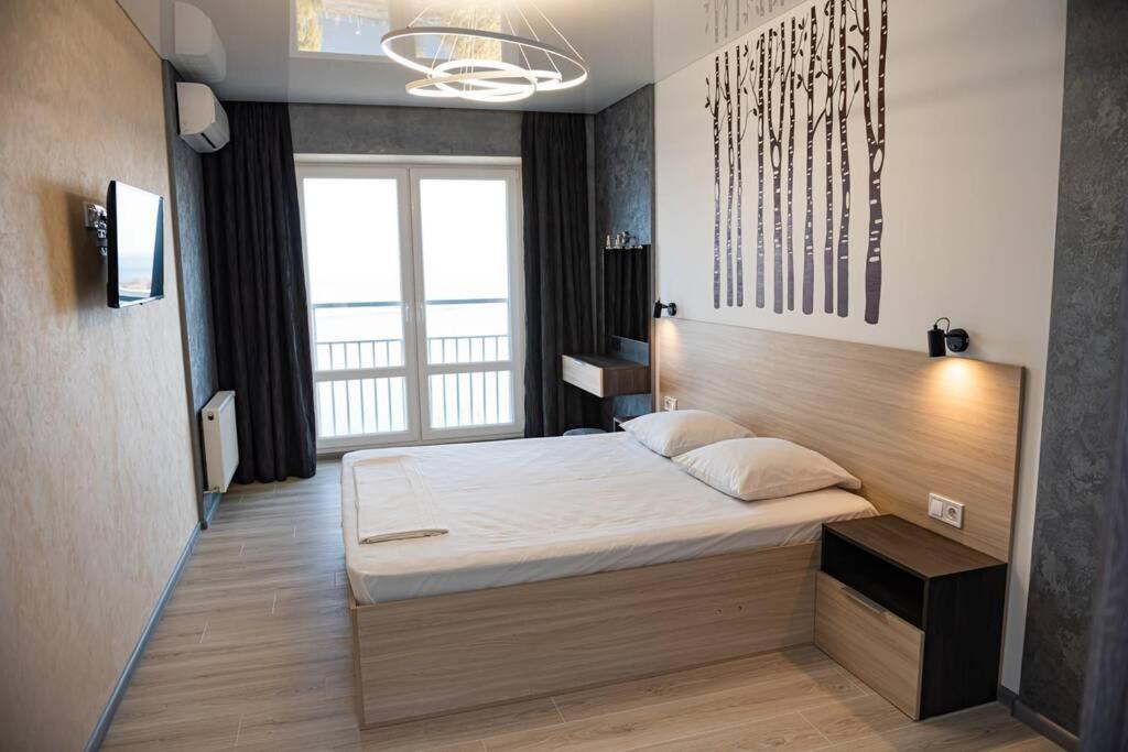 a bedroom with a bed in a room with a window at Квартира по ул. Козацкая 1/2 in Cherkasy