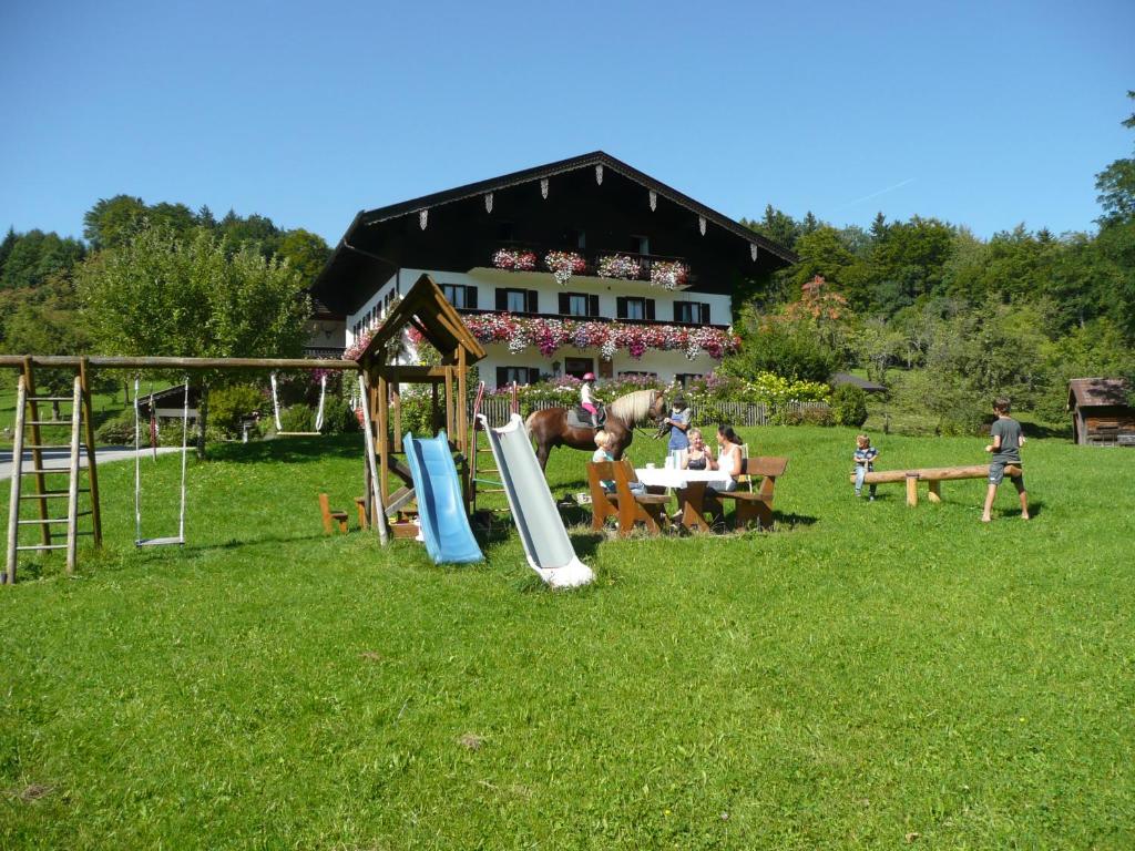 grupa ludzi bawiących się w trawie przed domem w obiekcie Adlerhof w mieście Samerberg