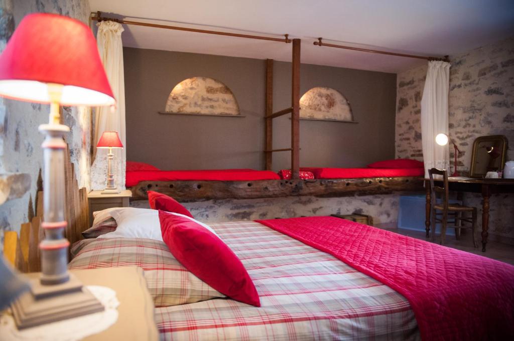 1 dormitorio con 2 camas y almohadas rojas en Chambres d'hôtes La Combe de Redoles en Tour-de-Faure