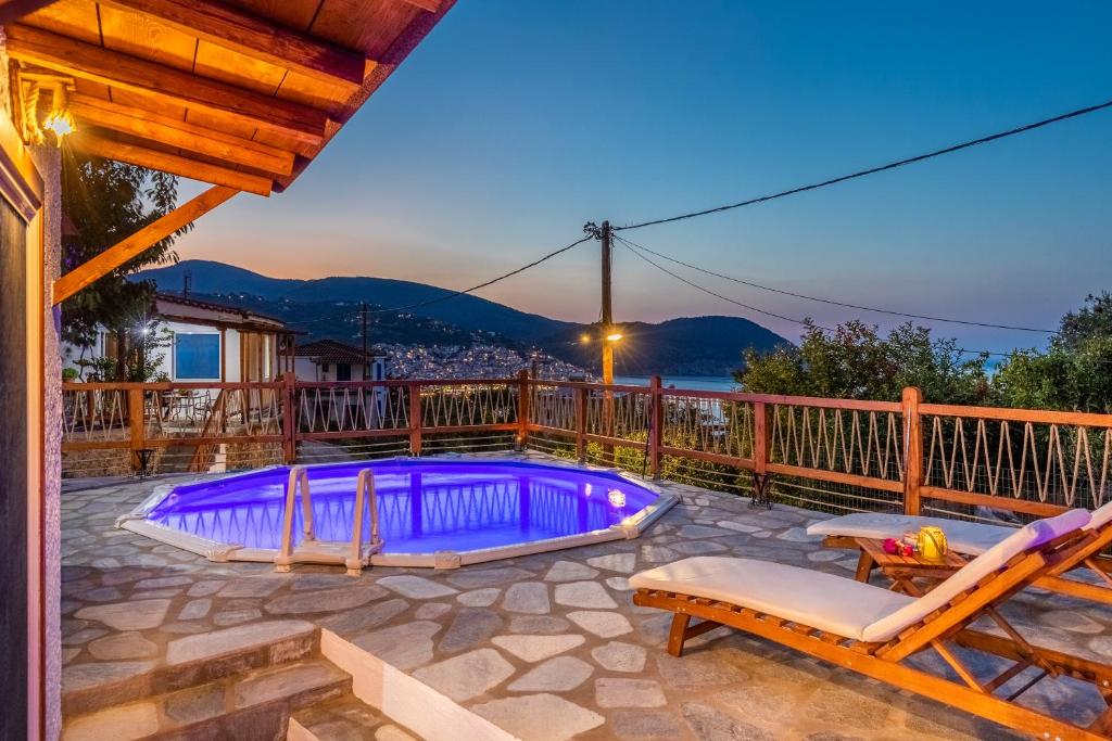 - une piscine sur une terrasse avec 2 chaises dans l'établissement Villa Watermill, à Skopelos