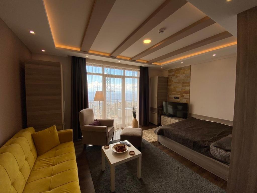 sala de estar con sofá amarillo y cama en Milmari Mountain view - I11, en Kopaonik