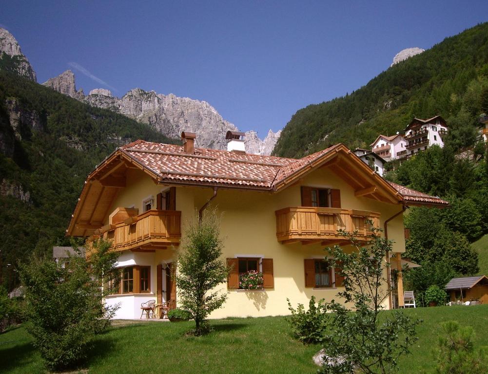 a house on a hill with mountains in the background at Casa Nonni in Molveno