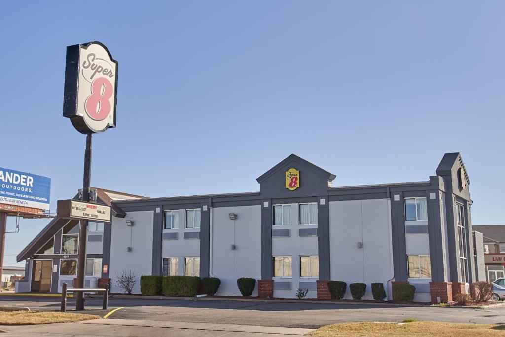 a building with a sign in front of it at Super 8 by Wyndham Wichita Airport West Kellogg in Wichita