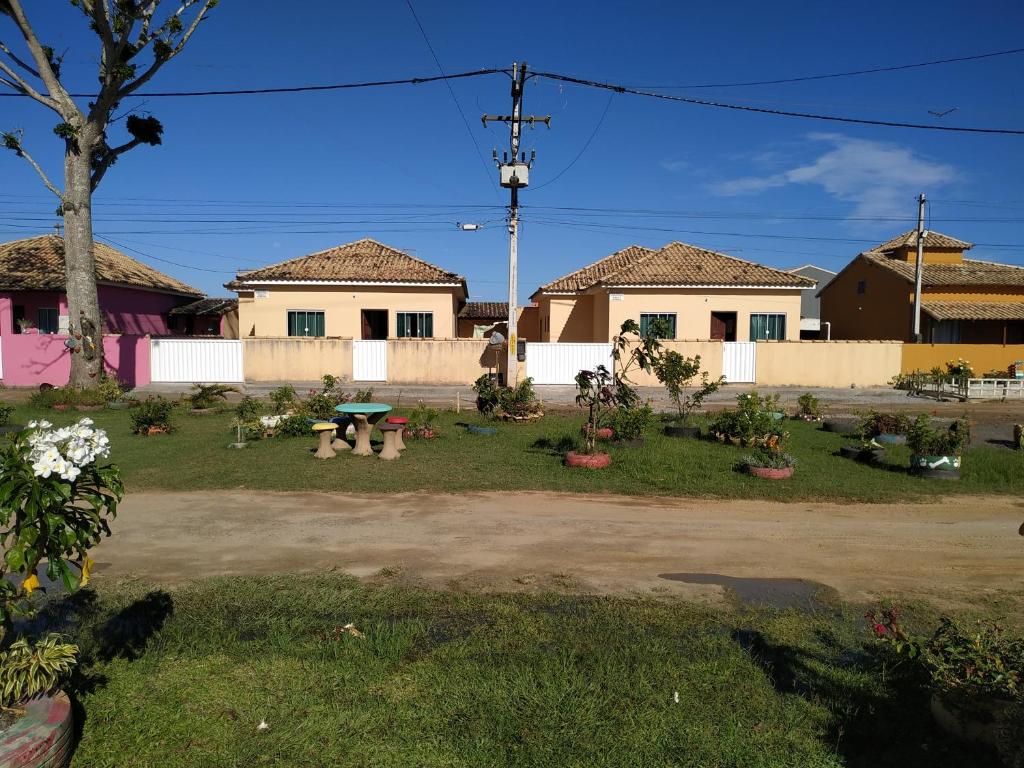 a yard with a picnic table and some houses at Casa em Unamar 3 Cabo Frio RJ in Tamoios
