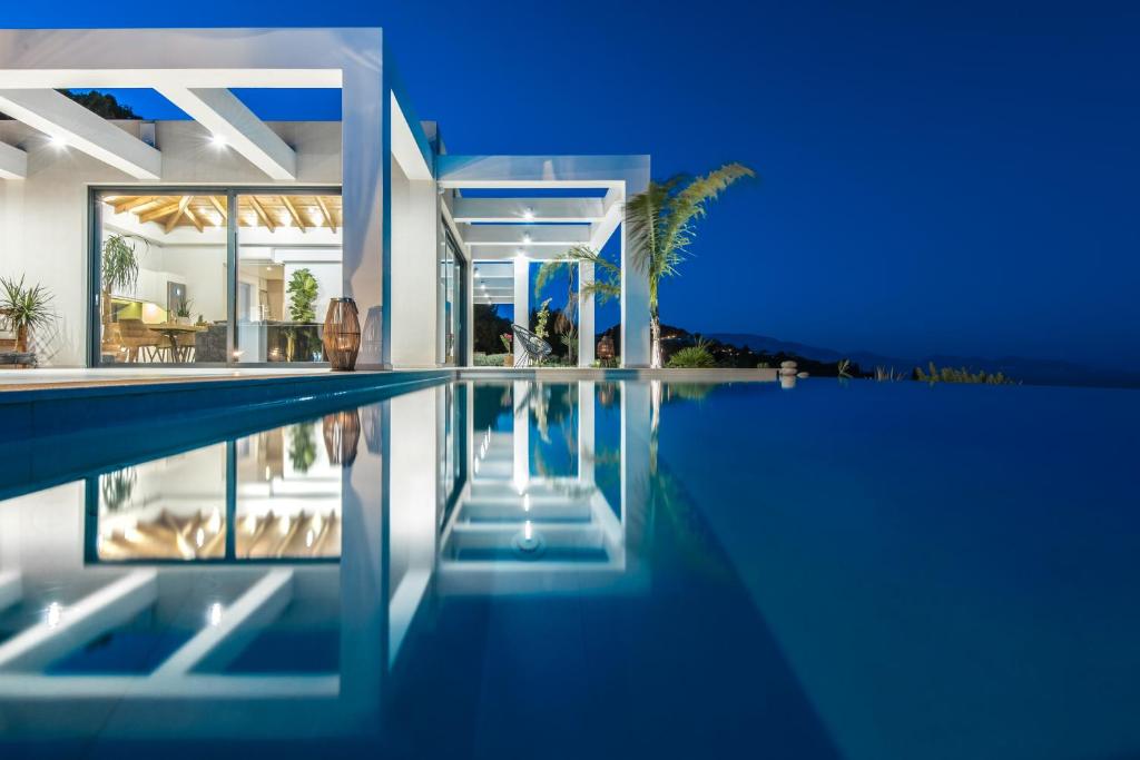 une villa avec une piscine la nuit dans l'établissement Horizon luxury villa, à Agios Nikolaos