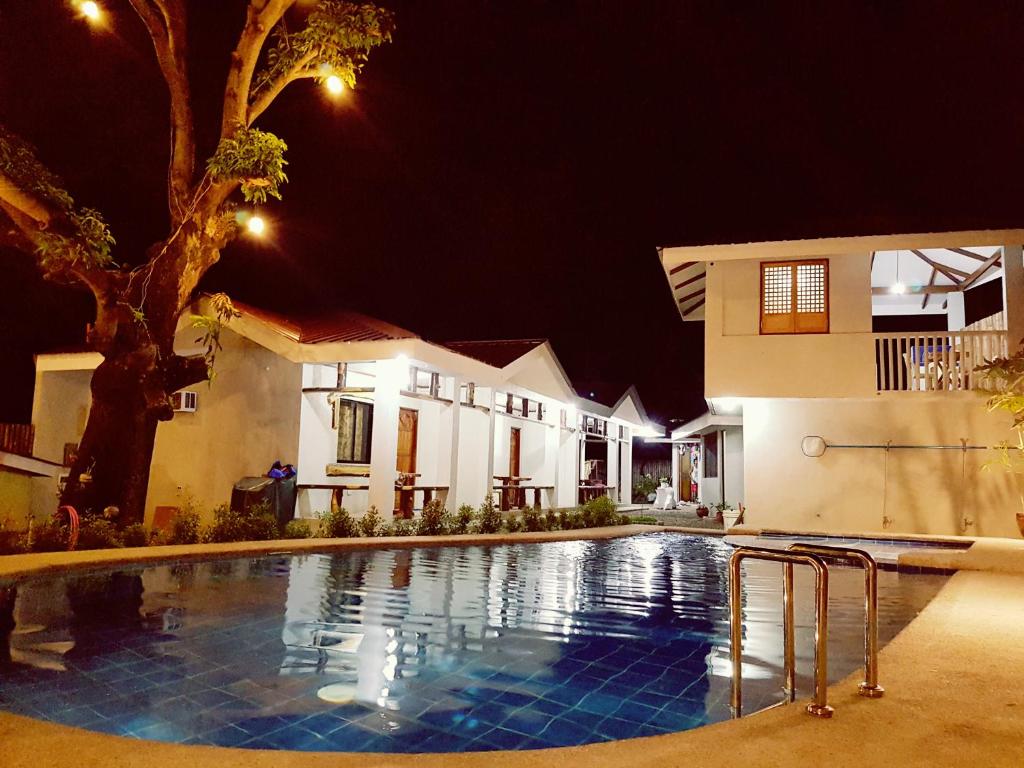 a swimming pool in front of a house at night at R&;S Restplace Resort in Matabungkay